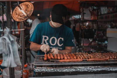 身穿蓝白圆领t恤的男子站在食品摊前